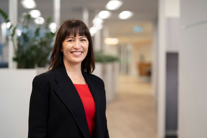 TelstraSuper CIO Kate Misic in red top looking at camera