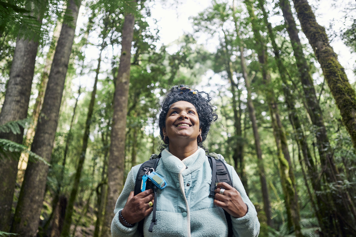 Woman exploring the rugged beauty of Tasmania's wilderness bushwalking through a temperate rainforest